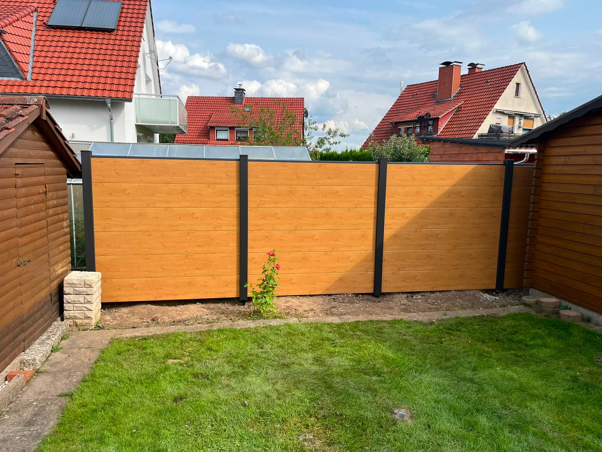 WPC Sichtschutzzaun in goldbrauner Holzoptik mit anthrazitfarbenen Aluminiumpfosten